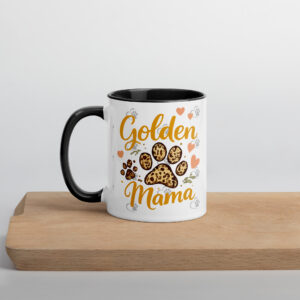 White mug with 'Golden Mama' orange script and cookie illustrations on a light background, black handle visible on the left.