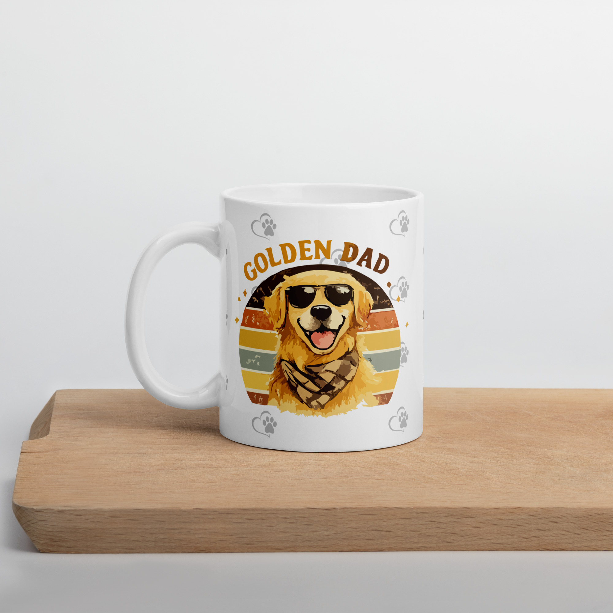 white-glossy-mug-white-11-oz-cutting-board-6a1b2b0708d27jpg - Golden Retriever Gift Shop Optional tagline if the builder asks for one: Life is Better with Goldens White mug on a wooden surface featuring a colorful Golden Dad dog design with a golden retriever and paw print accents.