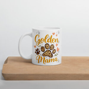 White ceramic mug with cookie illustrations and hearts, featuring orange script that says 'Golden Mama' on a wooden table surface.